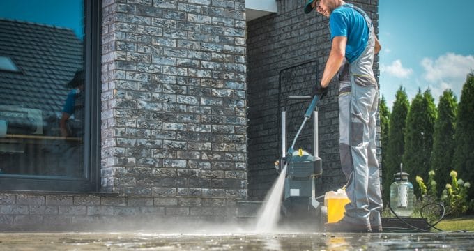 homme qui lave sol avec nettoyeur haute pression
