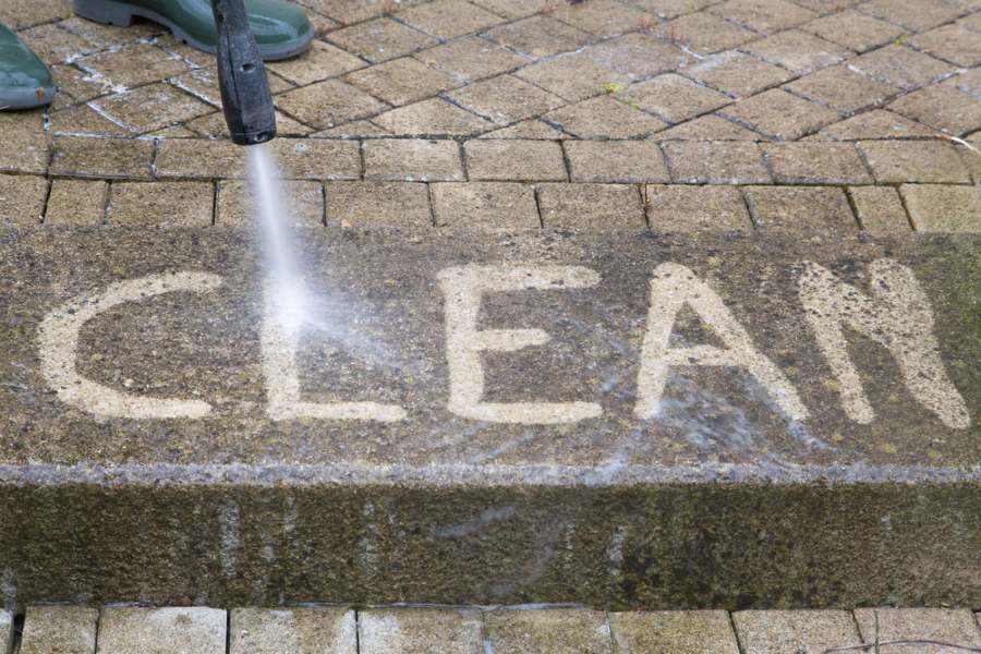 le mot clean ecrit au sol avec un nettoyeur haute pression