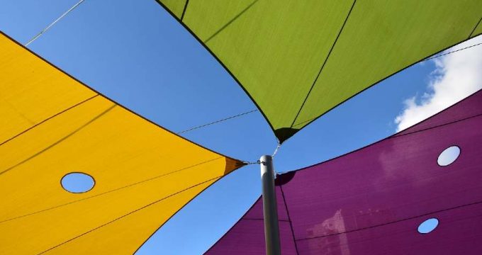 voiles d'ombrage de différentes couleurs vert, violet et jaune