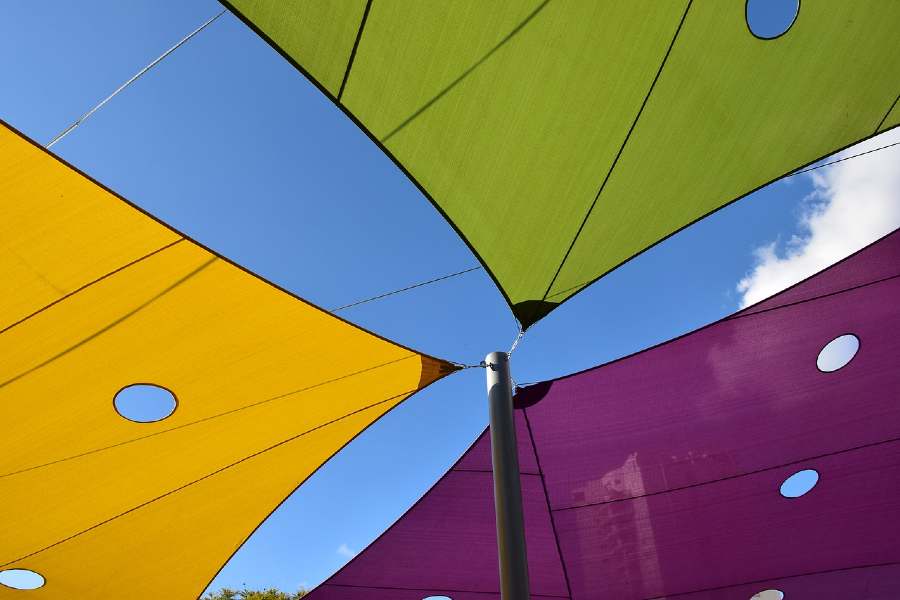 voiles d'ombrage de différentes couleurs vert, violet et jaune