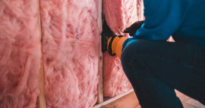 Homme posant isolation dans mur