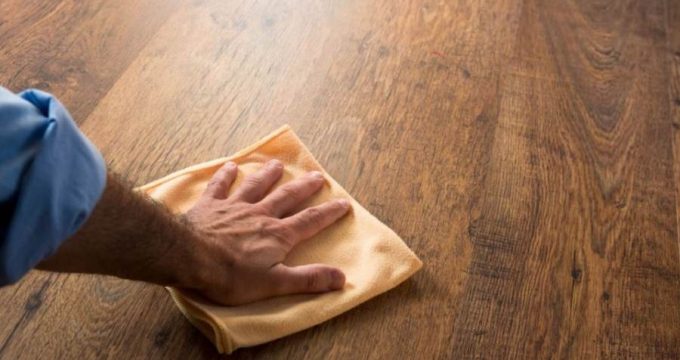 Un homme nettoie son parquet