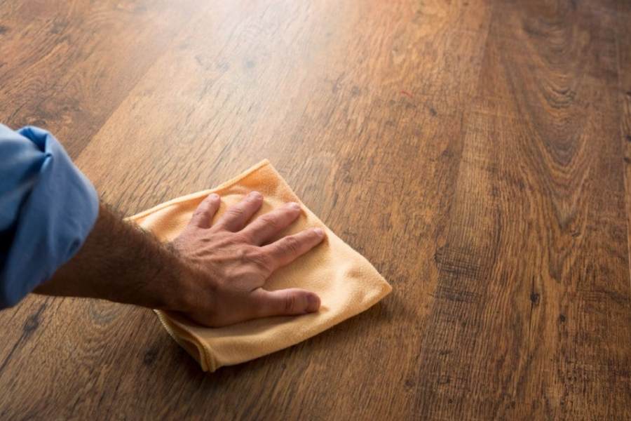 Un homme nettoie son parquet