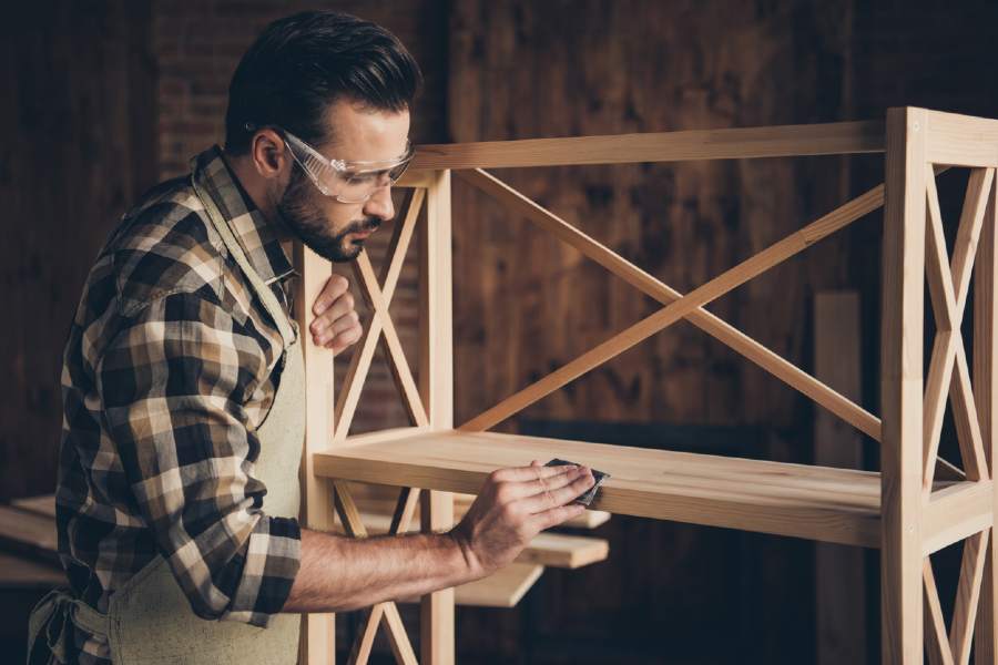 homme qui ponce le bois pour le blanchir