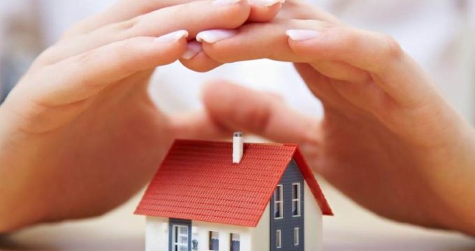 des mains protégent une maison miniature