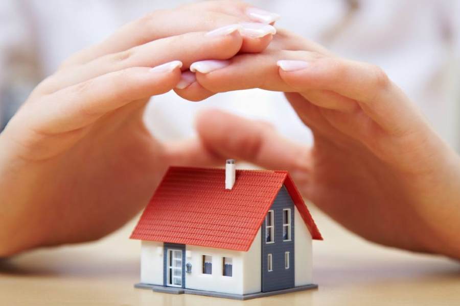 des mains protégent une maison miniature