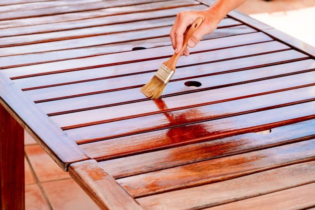personne vernissant table en bois