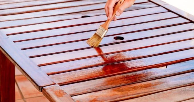 personne vernissant table en bois
