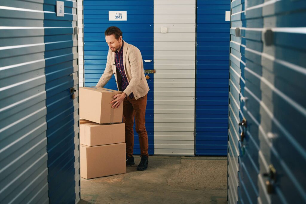 homme récupérant des cartons dans un box de stockage