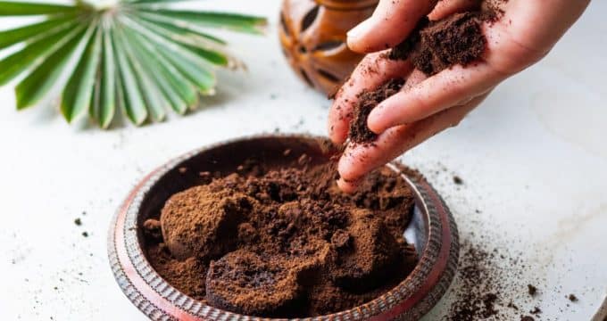 une femme émiette le marc de café