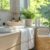 Lavabo blanc avec serviettes et plantes près de la fenêtre